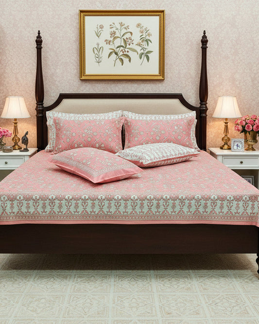 Pink floral patterned bedspread with matching pillows on a bed.