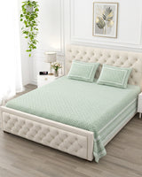 Booti Green bedsheet, sage-green lattice with tiny white booti, on a tufted ivory bed