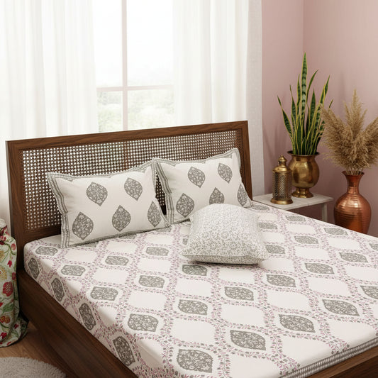 Patterned bedsheet with geometric and leaf designs on a bedspread.