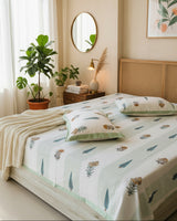Green botanical striped cotton bedsheet with matching pillow covers in a plant-filled bedroom