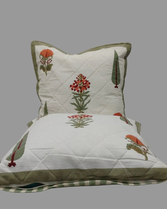 Two Gulmohar olive quilted cushion covers stacked to show the printed fronts and olive trim