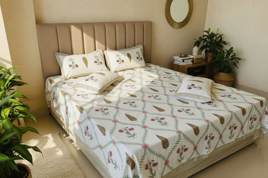Bed with floral patterned bedspread and pillows in a room.