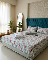 Blue trellis floral cotton bedsheet with magenta flowers styled on a teal tufted bed