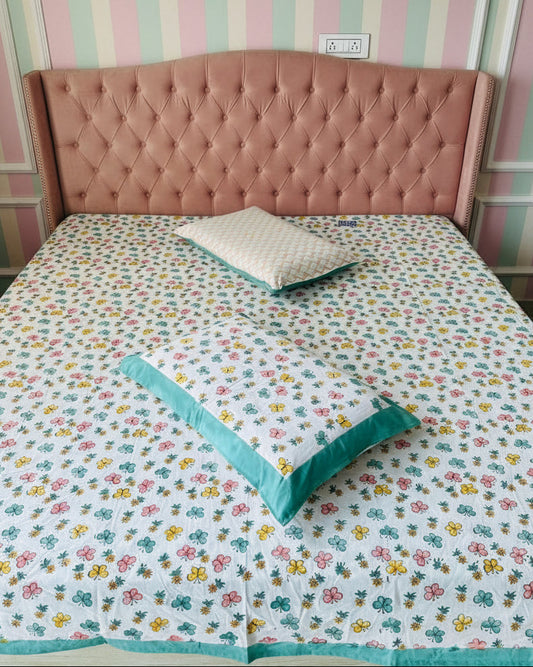 Bed with floral bedding and wooden headboard in a room.