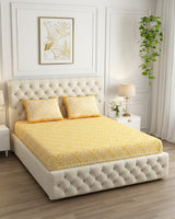 Aakriti Yellow bedsheet, marigold-yellow diamond-maze print, on a tufted ivory bed