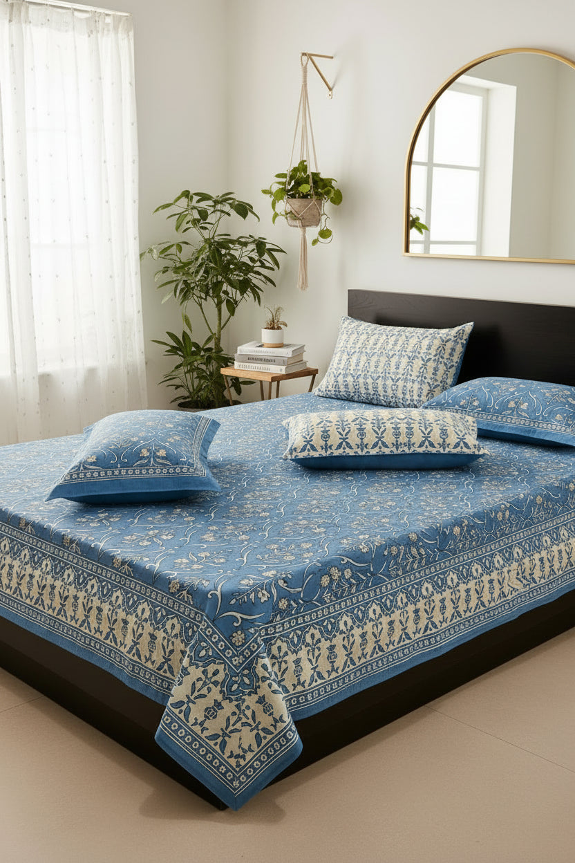 Blue floral patterned bedspread with matching pillow on a bed