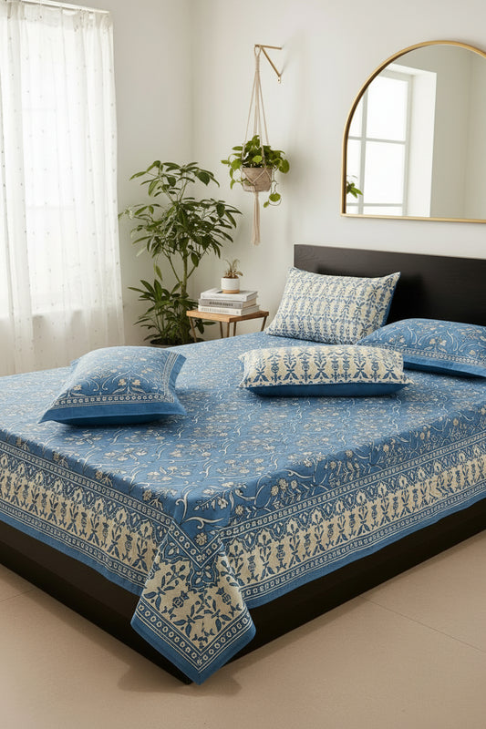 Blue floral patterned bedspread with matching pillow on a bed