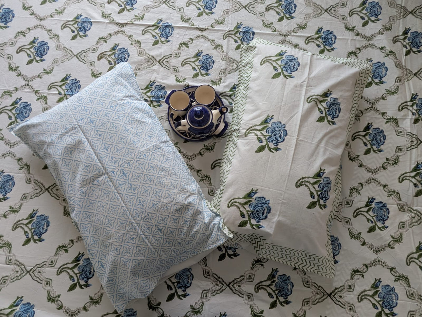 Decorative pillow and bedsheet on a blue floral-pattern