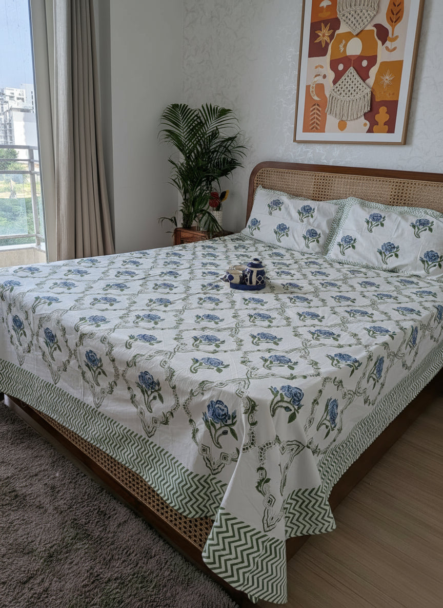 Bed with floral patterned bedding in a room with a city view.