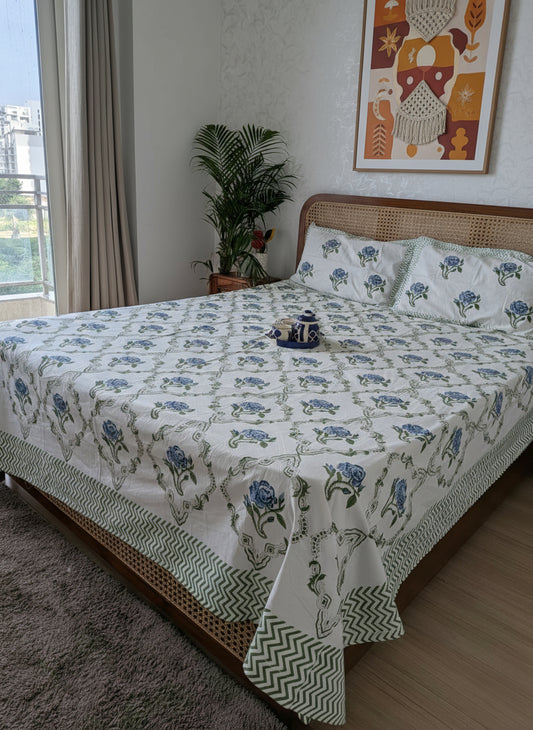 Bed with floral patterned bedding in a room with a city view.