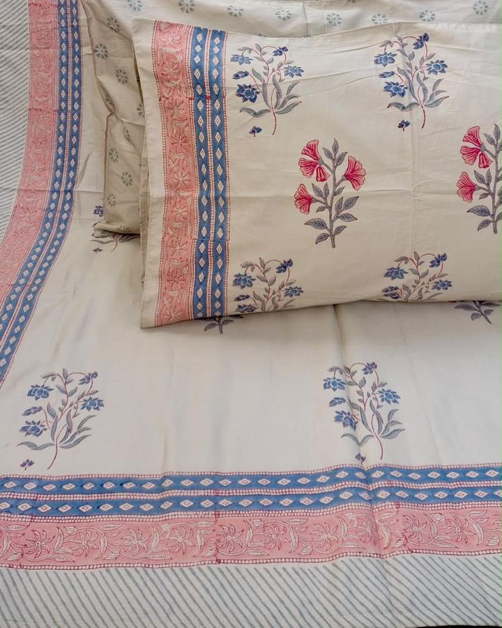 Aparajita hand block Percale Cotton bedsheet with pink and blue floral buta on ivory and a striped border, with pillow covers