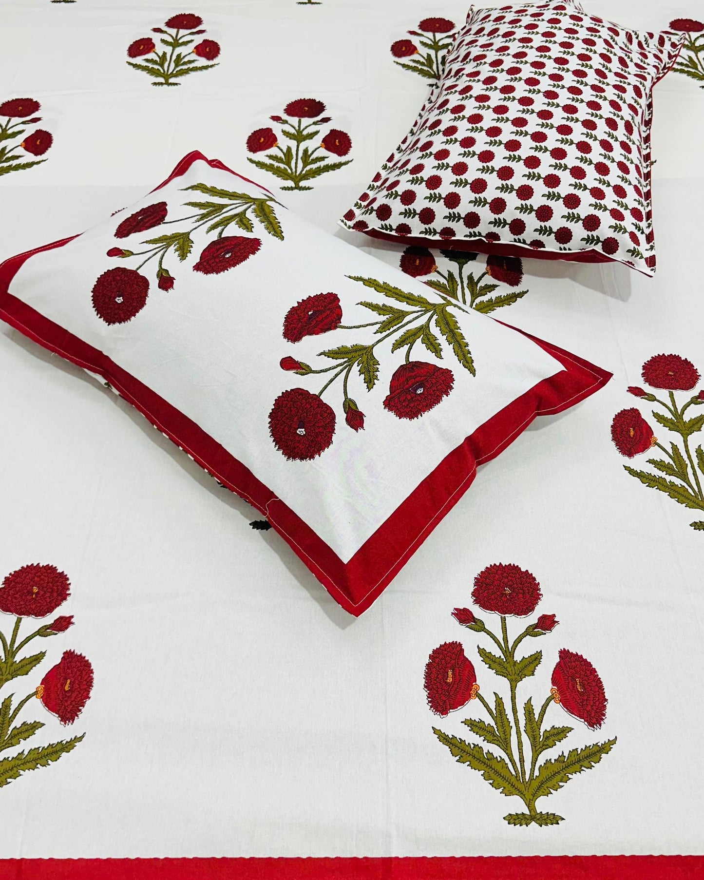 Floral patterned bedspread with matching pillows on a white background