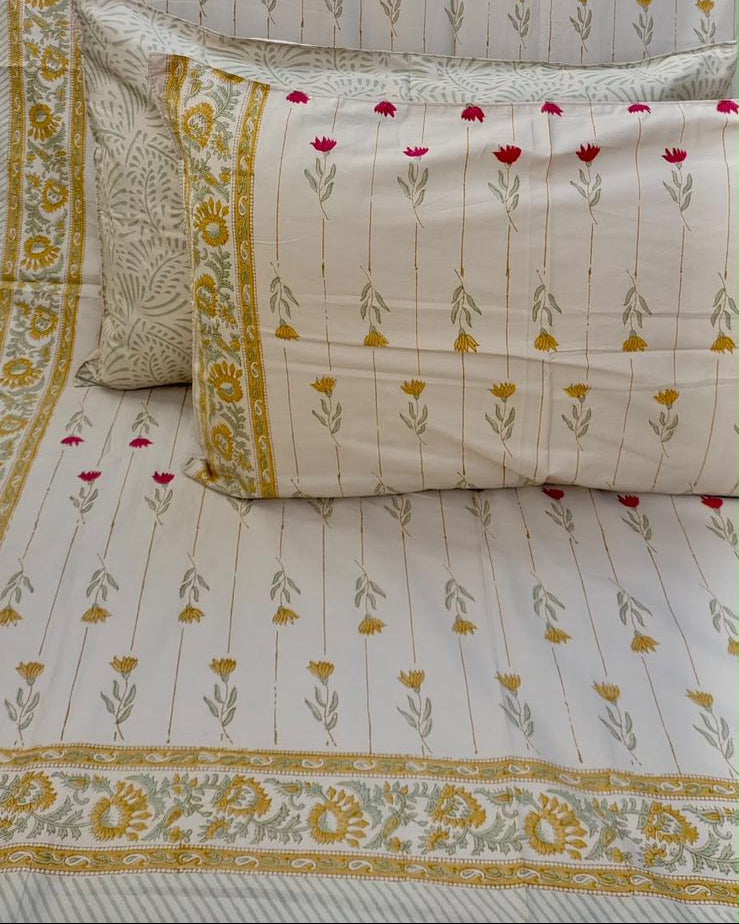 Basanti hand block Percale Cotton bedsheet with rows of red and mustard flower sprigs and a mustard floral border