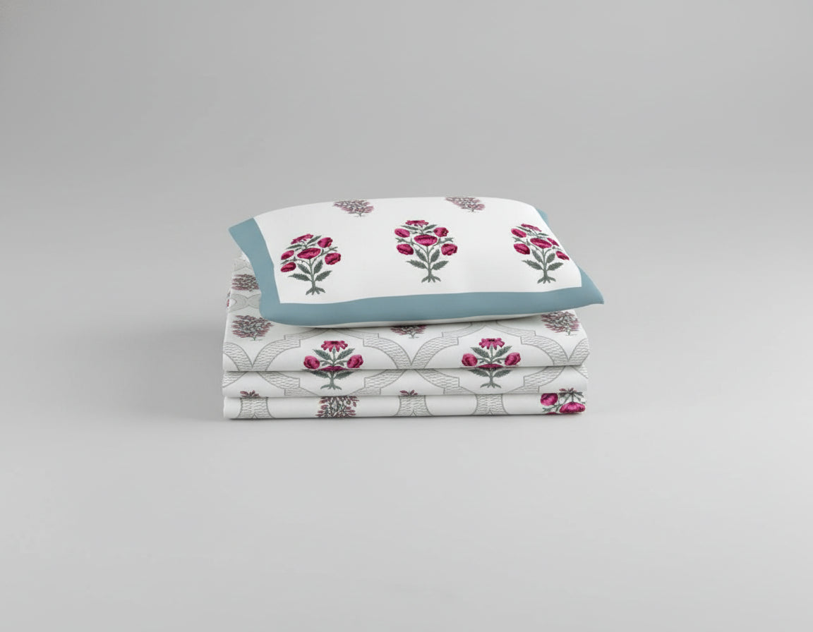 Floral patterned bedspread on a bed with matching pillows, surrounded by nightstands and decor.