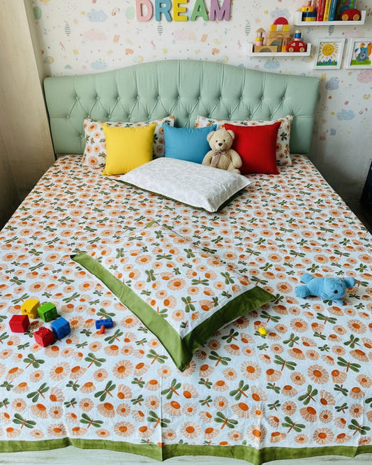 Bed with floral patterned bedspread and green border in a room.