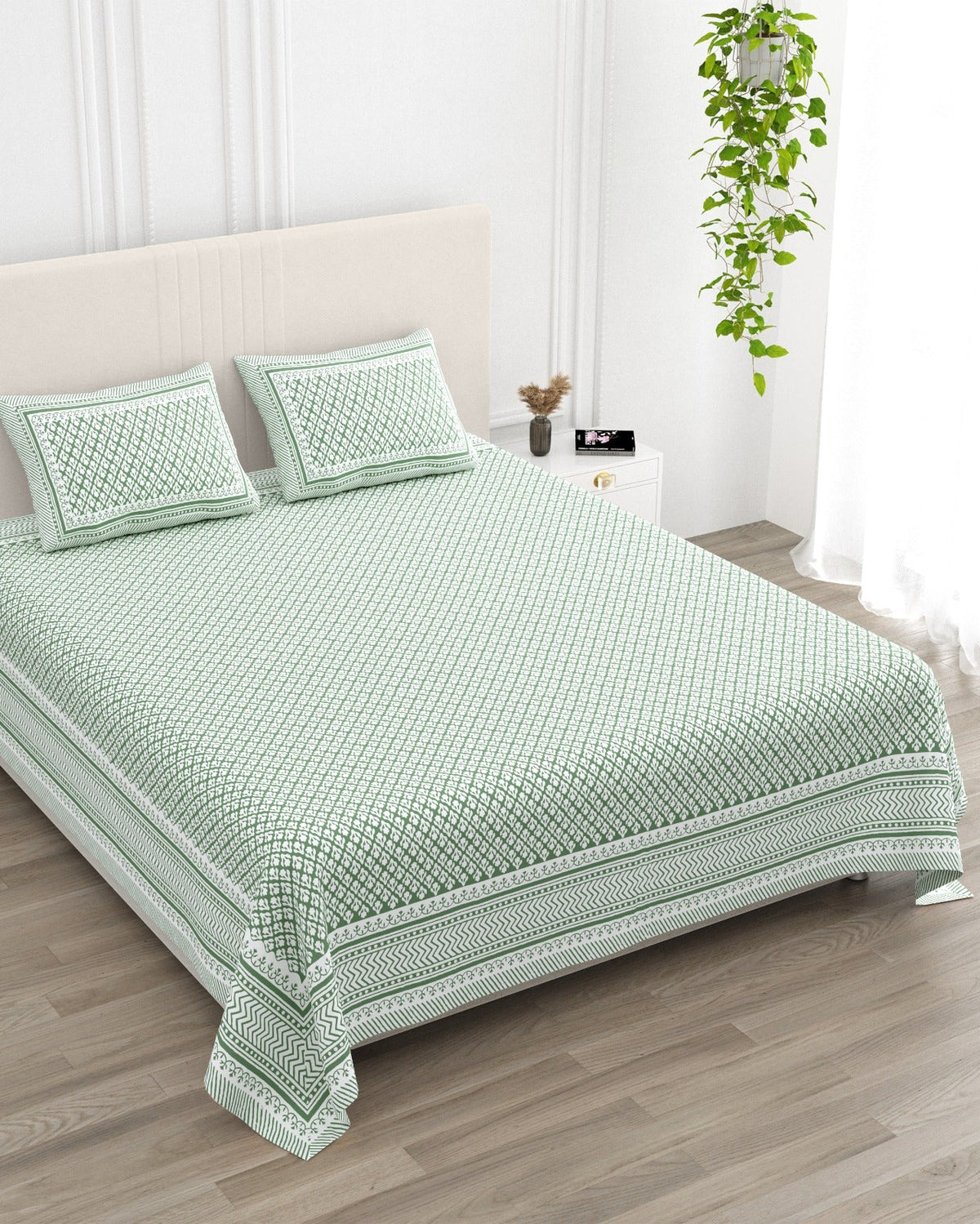 Booti Green bedsheet, sage-green lattice with tiny white booti, in a studio shot against a cream headboard