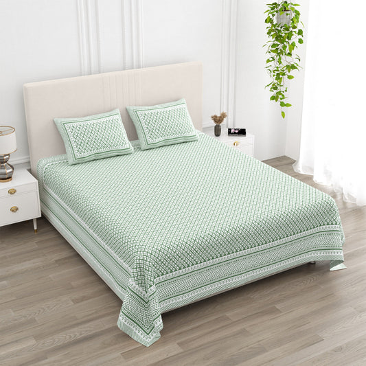 Booti Green bedsheet, sage-green lattice with tiny white booti, in a studio shot against a cream headboard