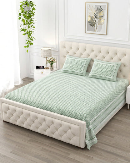 Booti Green bedsheet, sage-green lattice with tiny white booti, on a tufted ivory bed