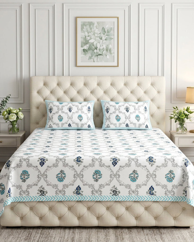 Chameli Blue bedsheet, grey trellis jaal on white with aqua bloom booti, on a tufted ivory bed