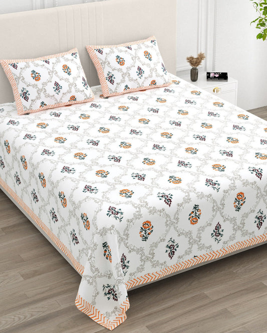 Chameli Orange bedsheet, grey trellis jaal on white with orange bloom booti, in a studio shot against a cream headboard