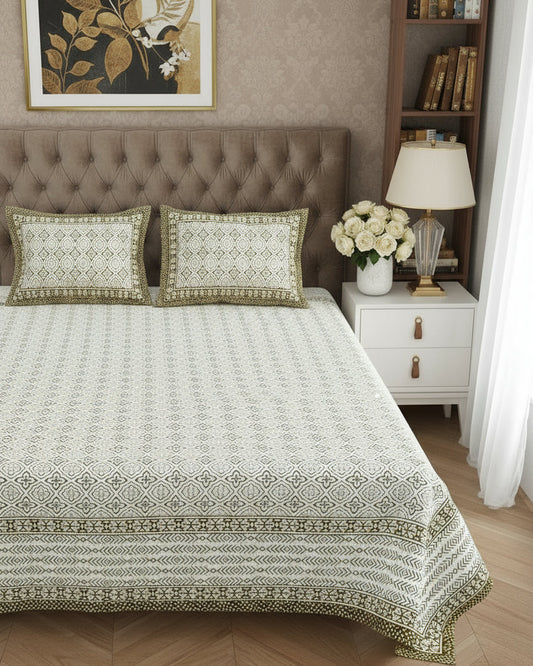 Decorative bedspread with intricate patterns on a bed in a bedroom setting.