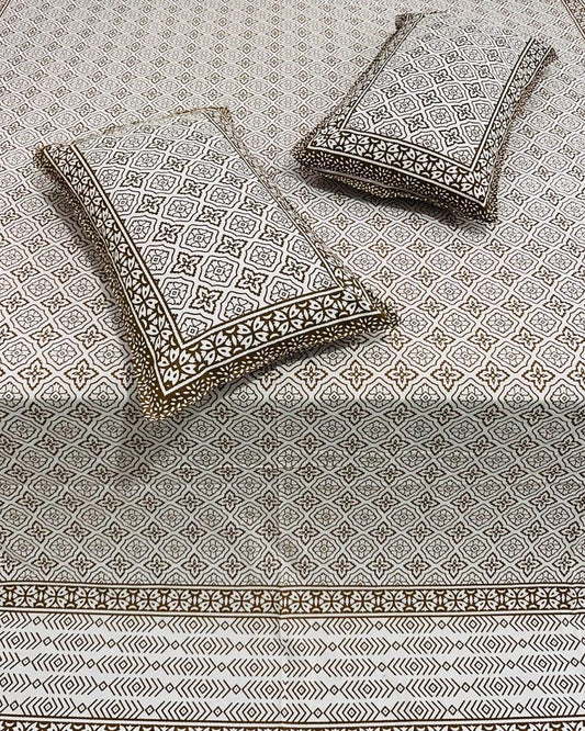 Decorative pillows with intricate patterns on a matching fabric background