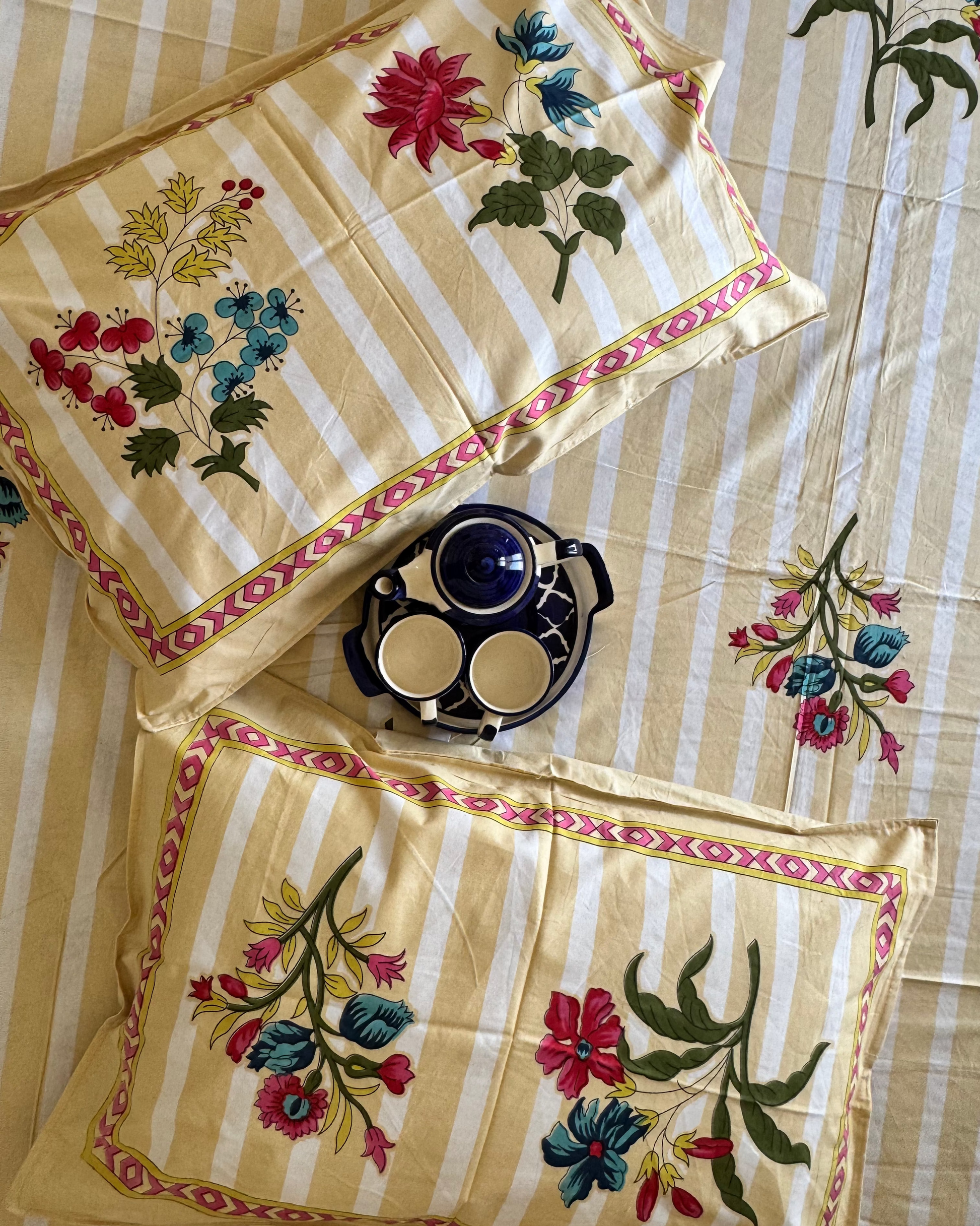 Close-up of Dhaari Peach pillow covers showing the striped ground and multicoloured floral sprigs