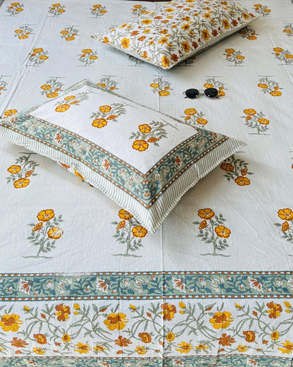 Close-up of ivory cotton fabric with yellow marigold booti and a sage floral border