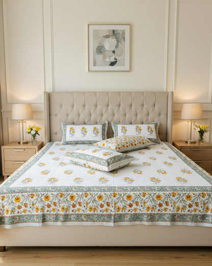 Gendika yellow marigold cotton bedsheet with floral pillow covers against a damask wallpaper