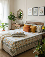 Yellow marigold booti cotton bedsheet with matching pillow covers on a beige tufted bed