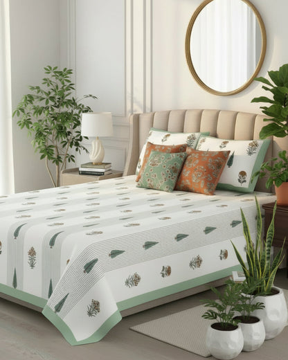 Sage green tree motif cotton bedsheet styled on a beige tufted bed with a round mirror