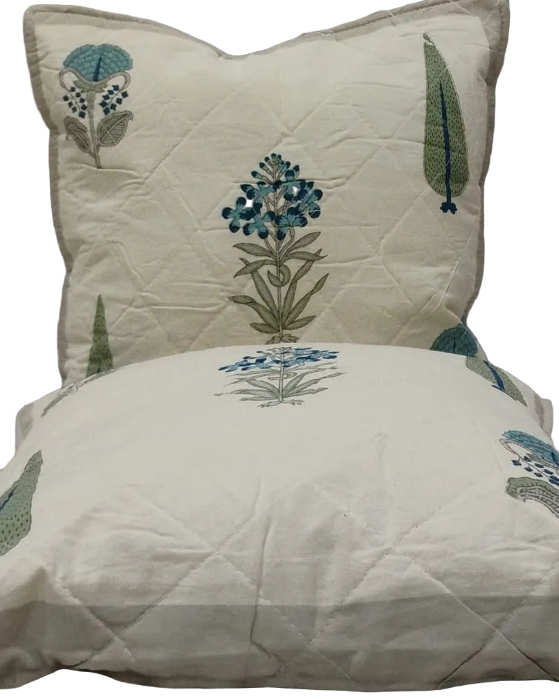Two Gulmohar grey quilted cushion covers stacked to show the blue floral print