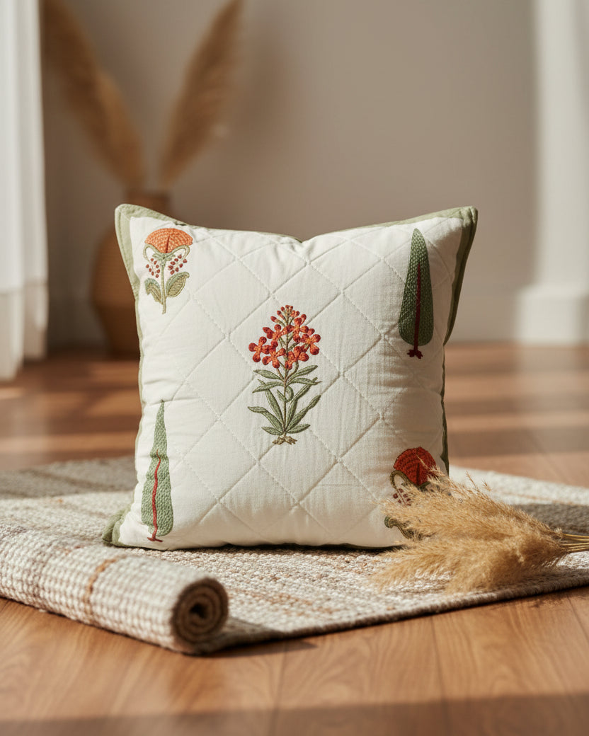 Gulmohar olive quilted cushion cover styled with orange floral and green tree motifs