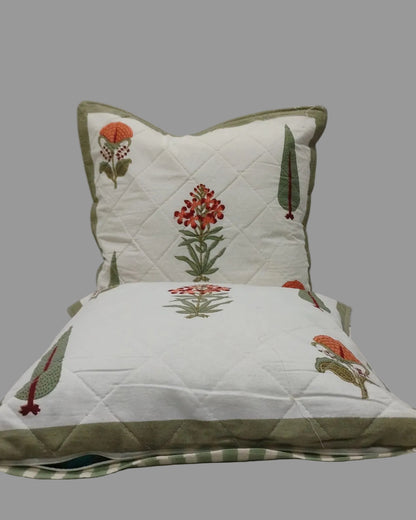 Two Gulmohar olive quilted cushion covers stacked to show the printed fronts and olive trim