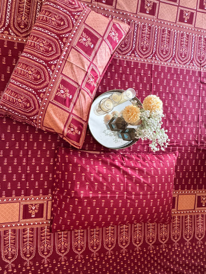 Close-up of Tarang Red bedsheet and pillow cover with a tray of flowers
