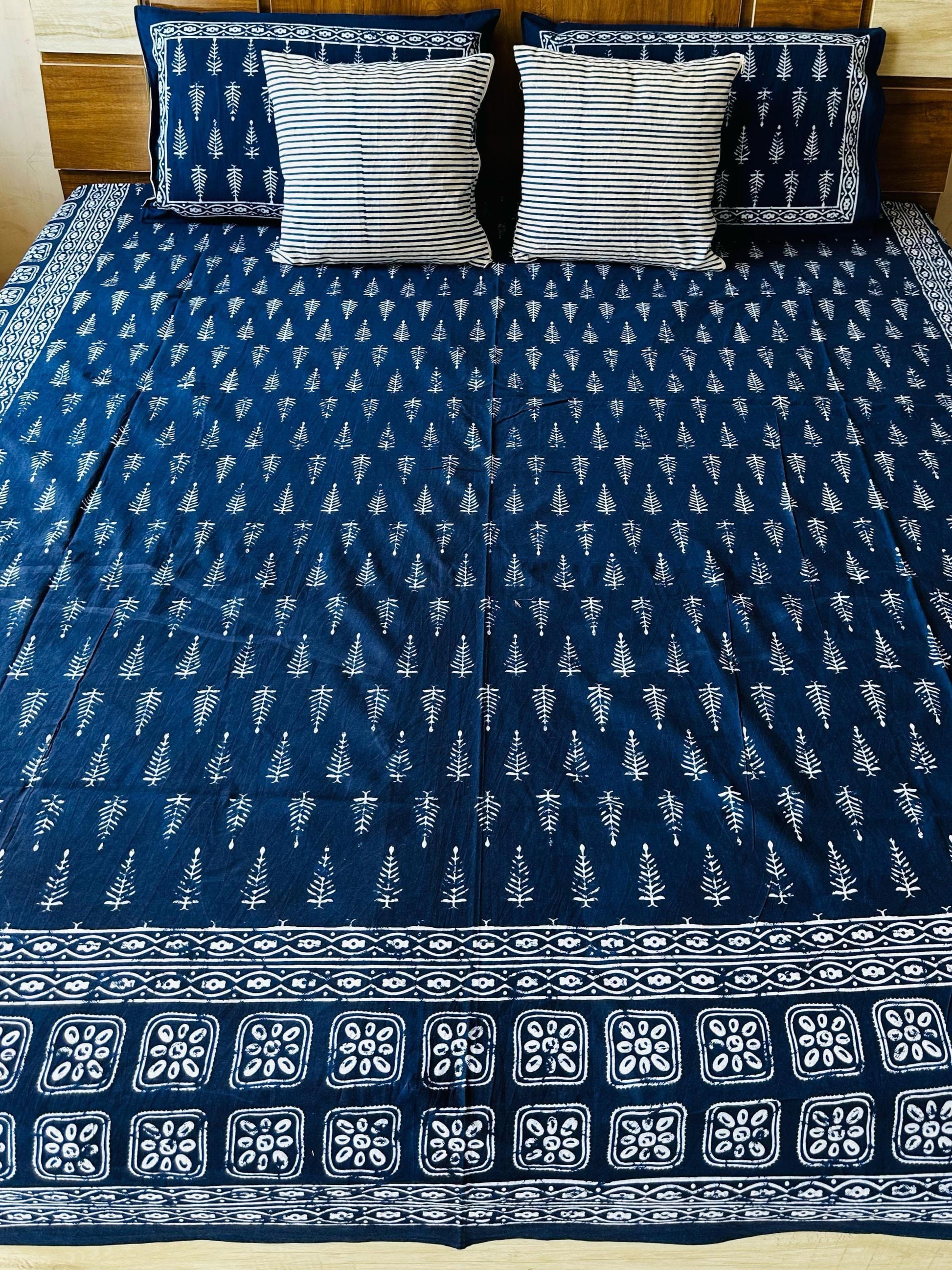 Bed with blue and white patterned cover in a bedroom setting