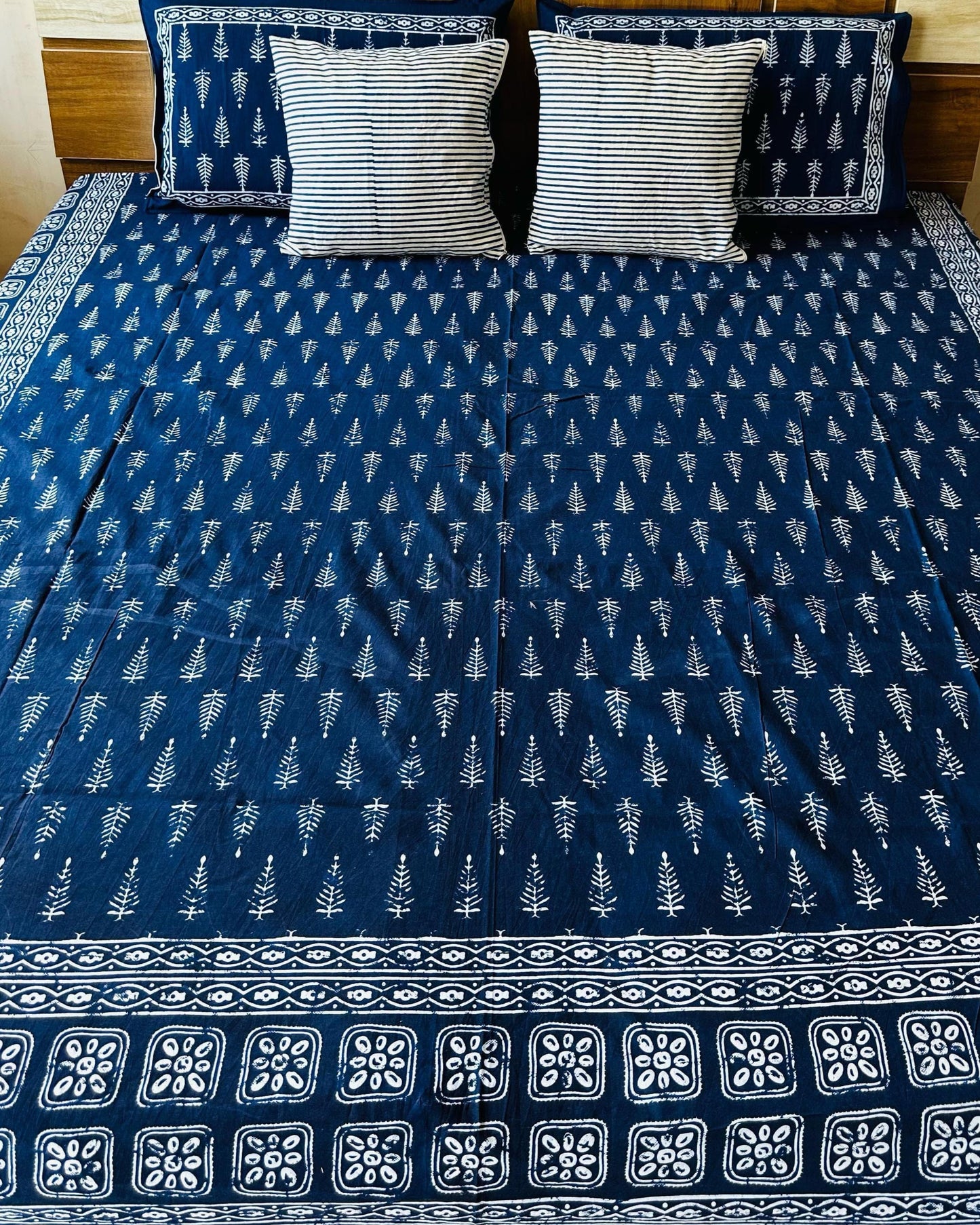 Bed with blue and white patterned cover in a bedroom setting