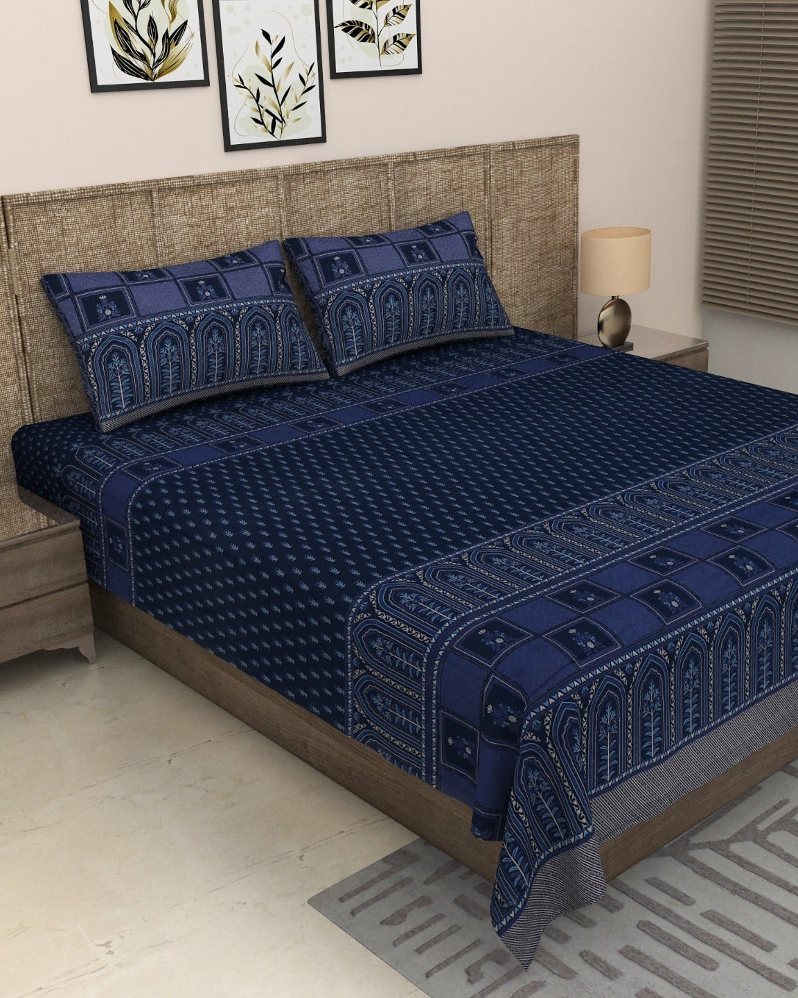 Tarang Blue navy bedsheet with tonal arched border on a grey upholstered bed