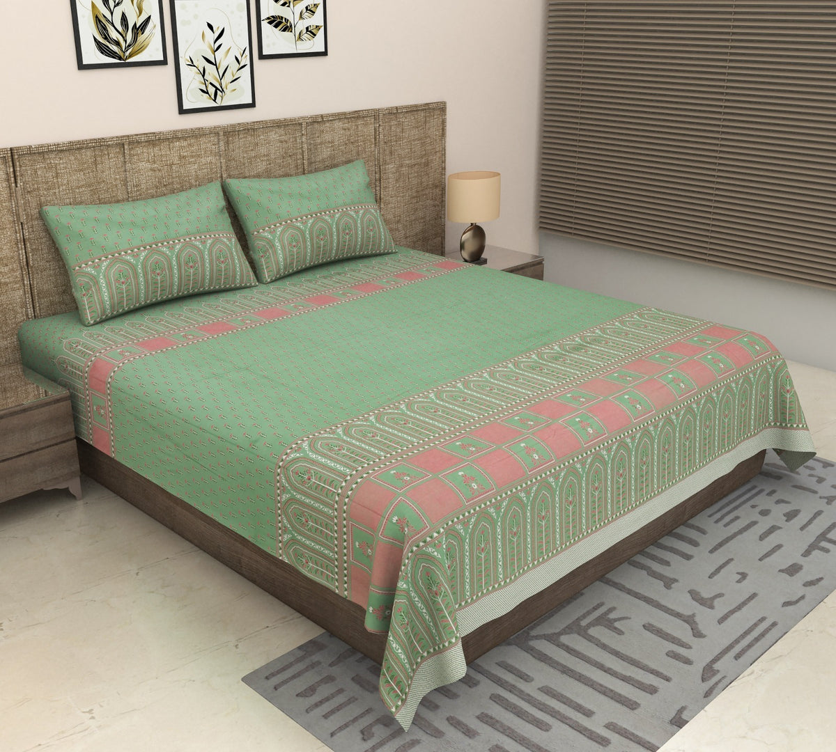 Tarang Green mint bedsheet with pink border on a grey upholstered bed