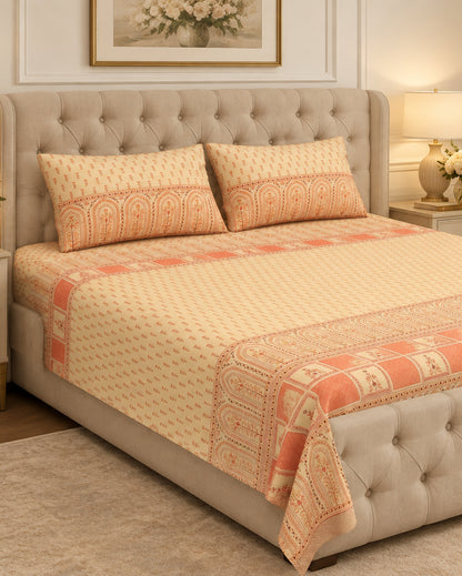 Tarang Peach bedsheet and pillow covers on a grey tufted bed