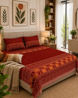 Tarang Red Everyday Cotton bedsheet with small motifs on red and an ornate peach-toned arched border, with a beige throw