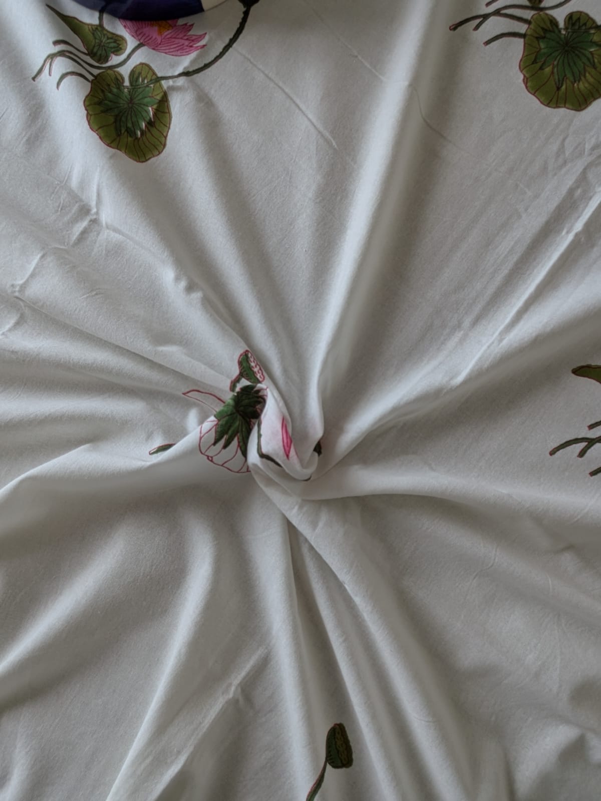 White fabric with floral lotus motifs on a white background