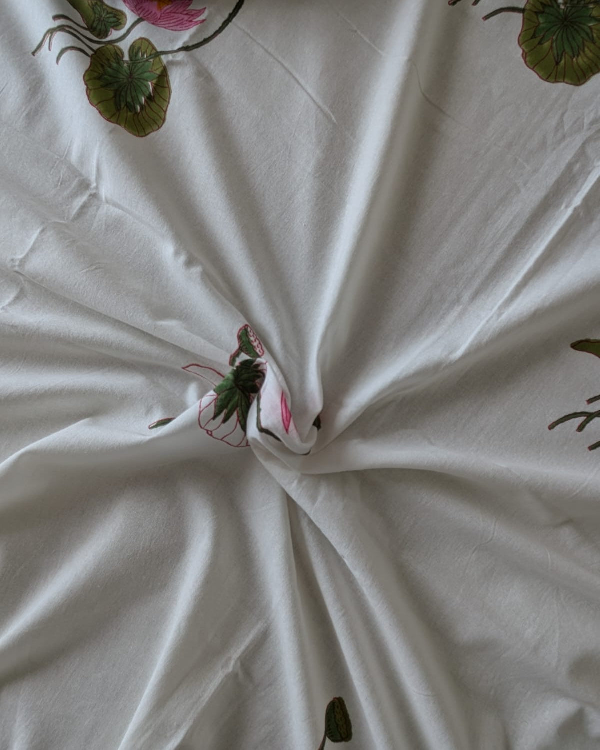 White fabric with floral lotus motifs on a white background