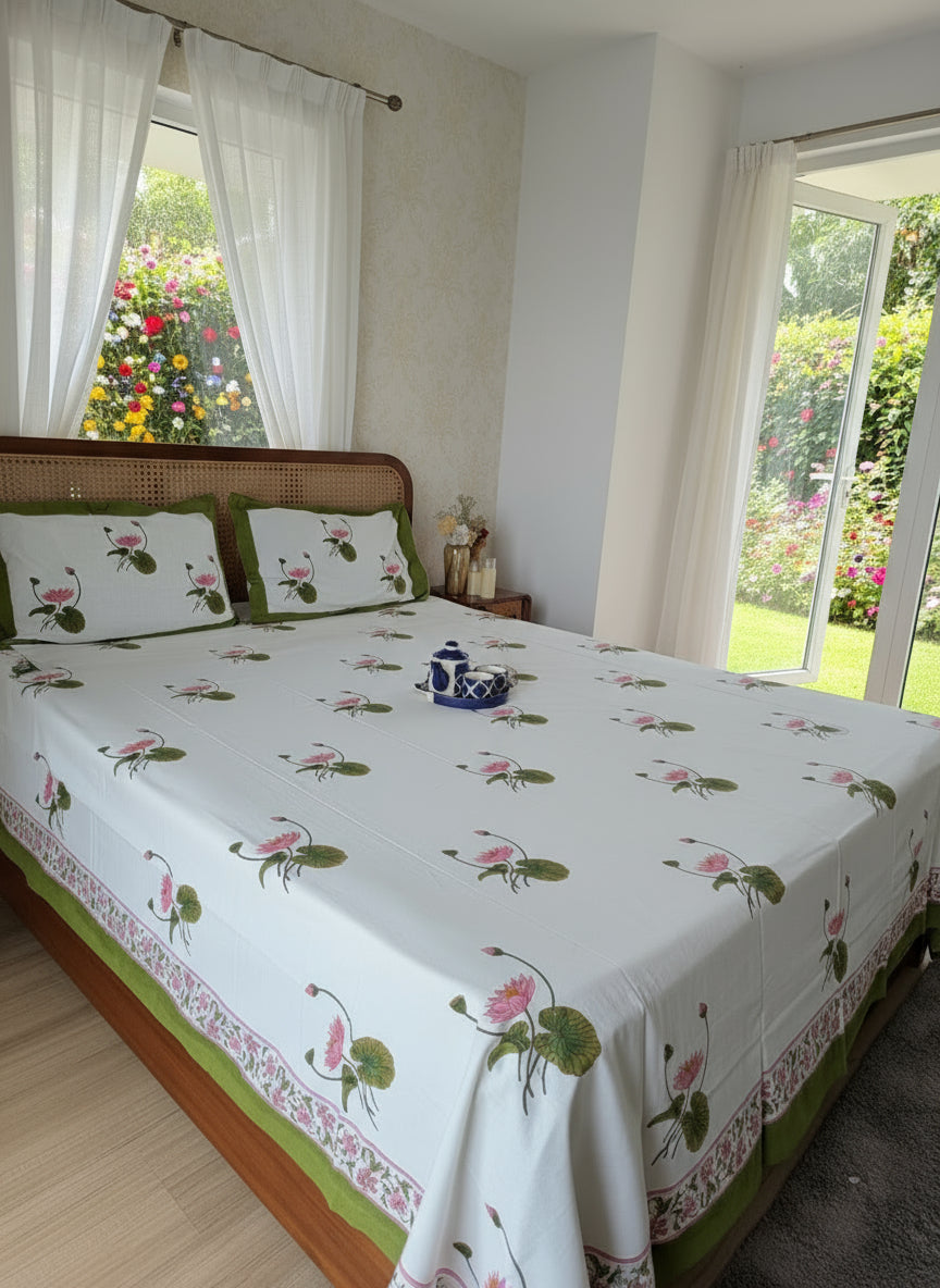 Bed with floral patterned bedsheet and pillows in a room.