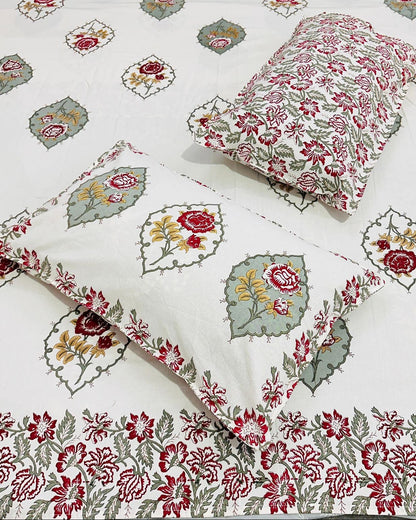 Close-up of ivory cotton fabric with deep maroon rose florals and sage green accents