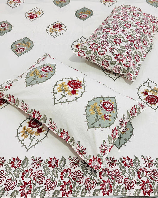 Close-up of ivory cotton fabric with deep maroon rose florals and sage green accents