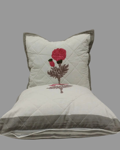 Two Kesariya grey quilted cushion covers stacked to show the pink floral print and grey trim