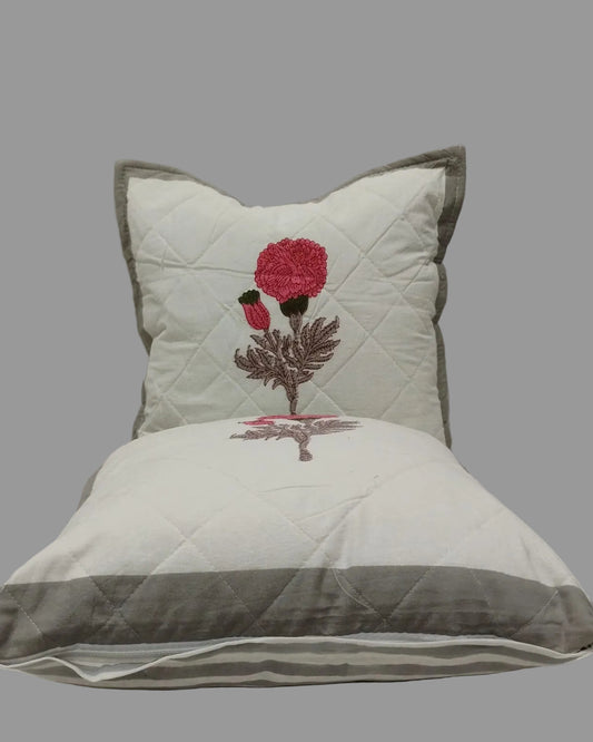 Two Kesariya grey quilted cushion covers stacked to show the pink floral print and grey trim