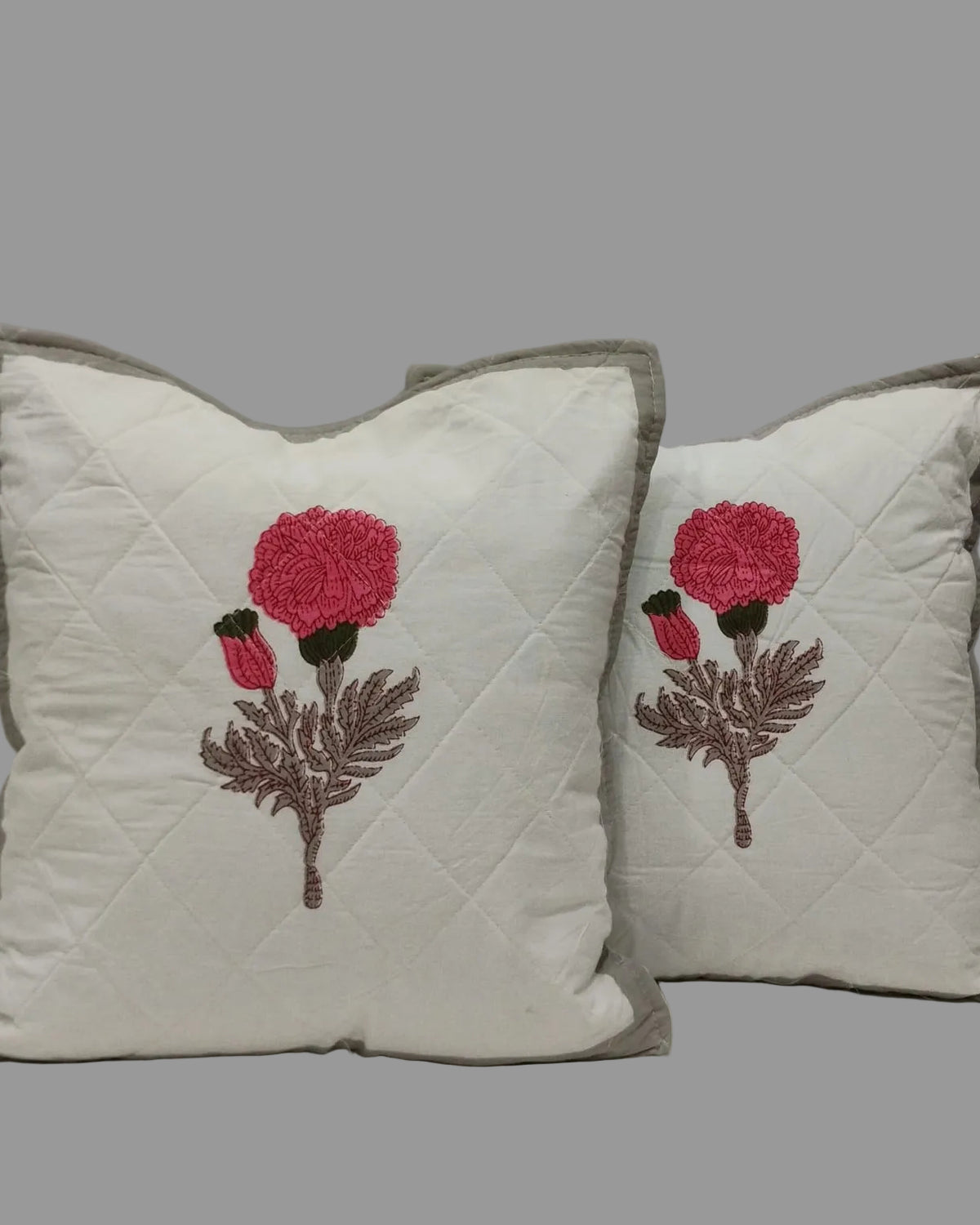 Pair of Kesariya grey quilted cushion covers with central pink flower motifs