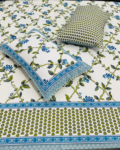 Close-up of Everyday Cotton fabric with blue flowers, green vine leaves and a green and blue printed border